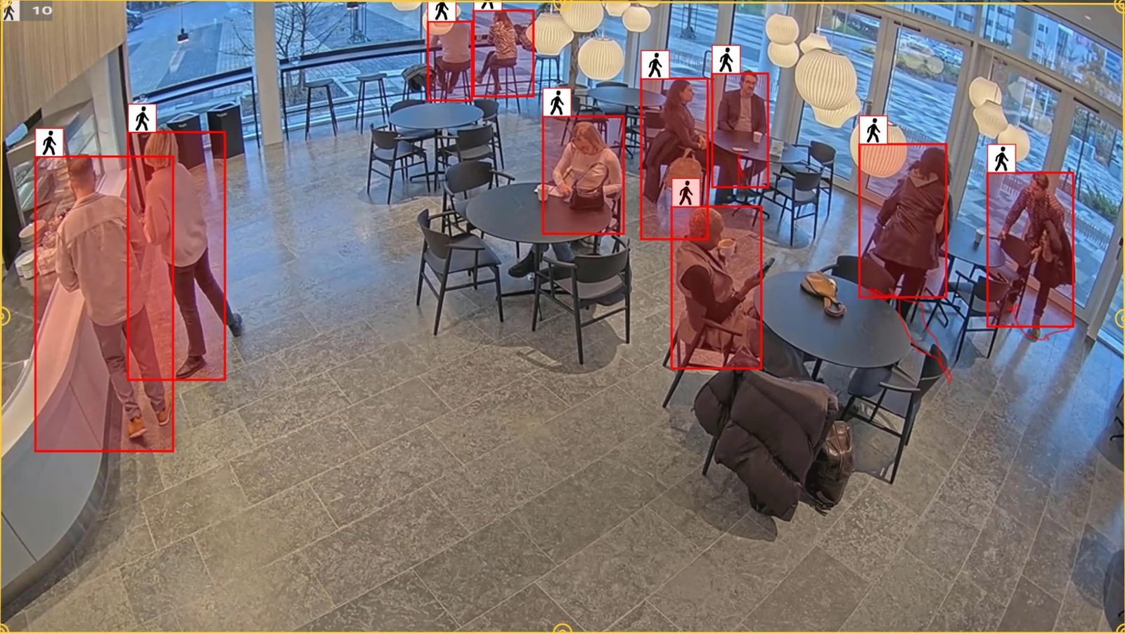 Computer vision detecting every person in a busy dining and lobby area, drawing a box around each for occupancy, queue and traffic analytics.